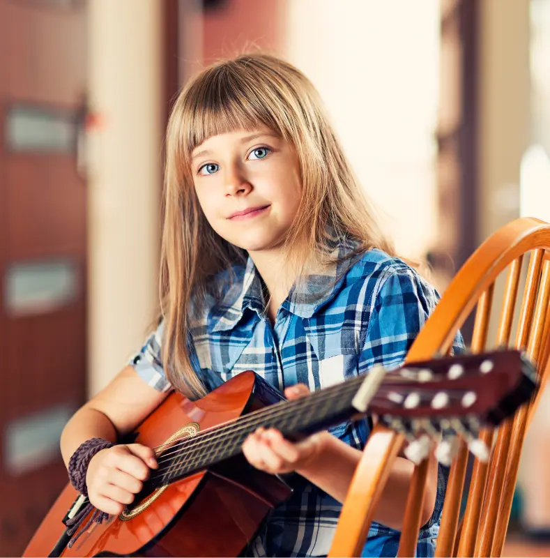 Quel instrument choisir pour un enfant ? Jeune fille apprend la guitare classique adaptée à sa taille.
