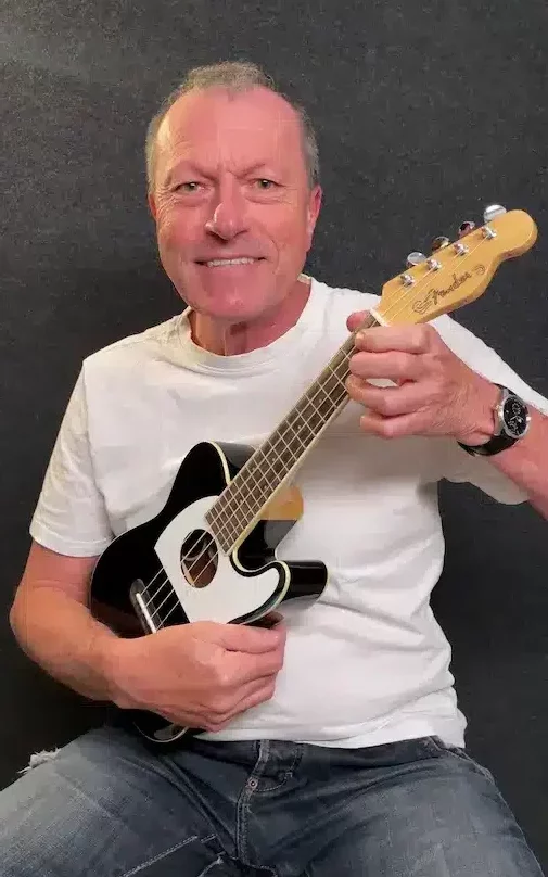 Denis joue du ukulélé électro acoustique Fender stratocaster. C'est un ukulélé différent de la guitare