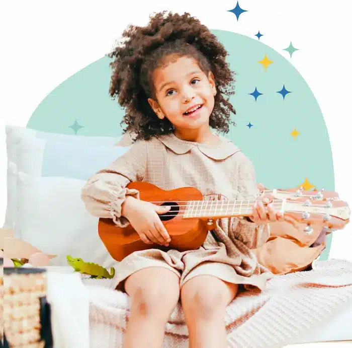 Petite fille souriante qui apprend à jouer du ukulélé à la maison